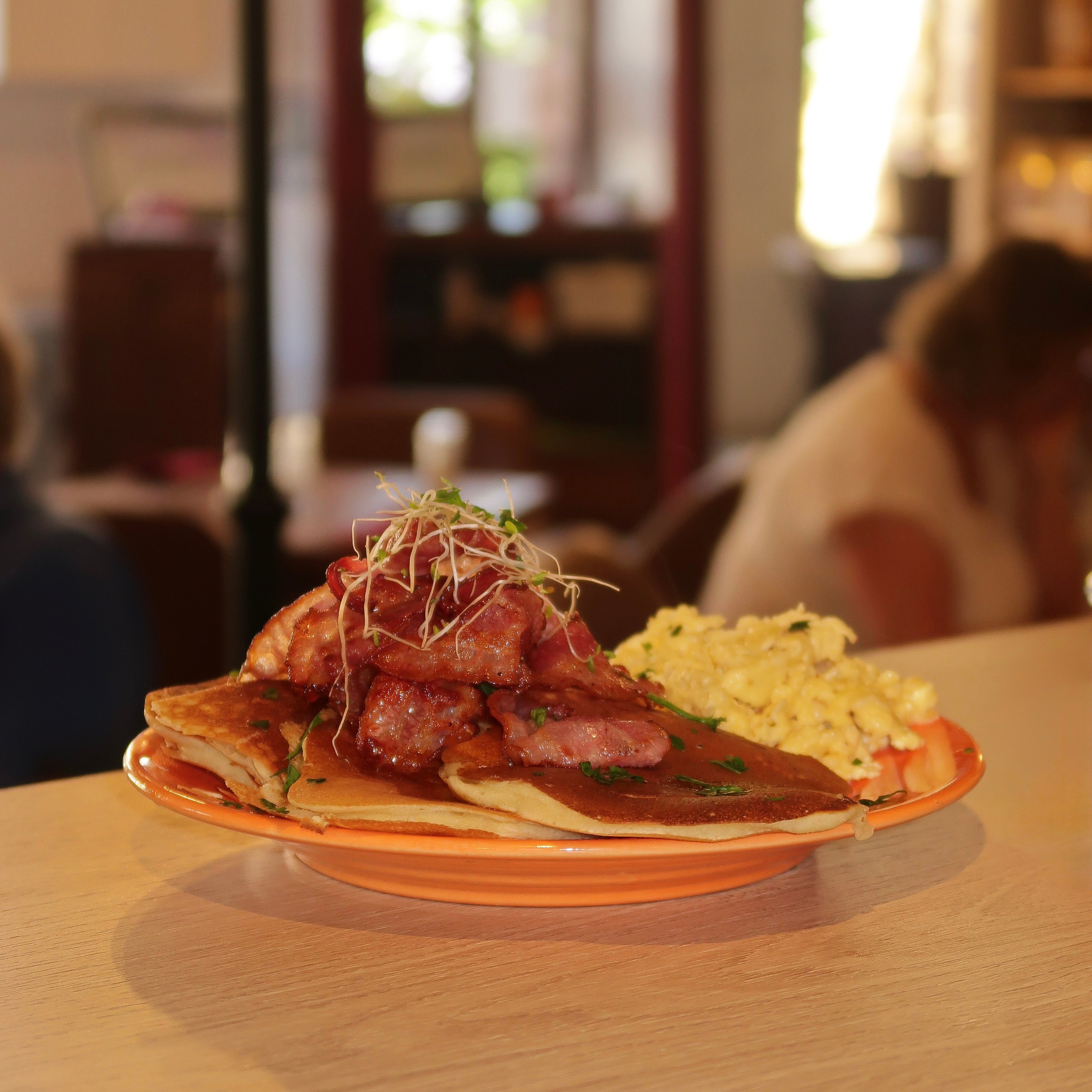 Pancakes avec œufs brouillés et bacon avec du sirop 